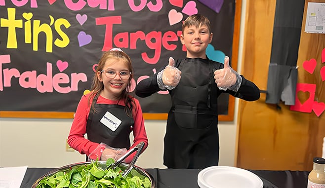 To kids in front of a poster