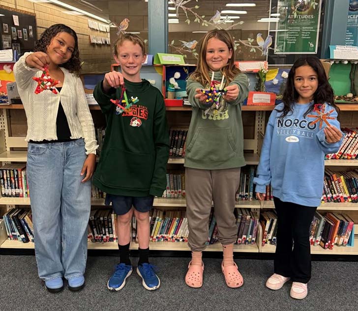 A group of four kids displaying things they made